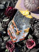 Halloween-themed card with decorative elements on a dark background with flowers.